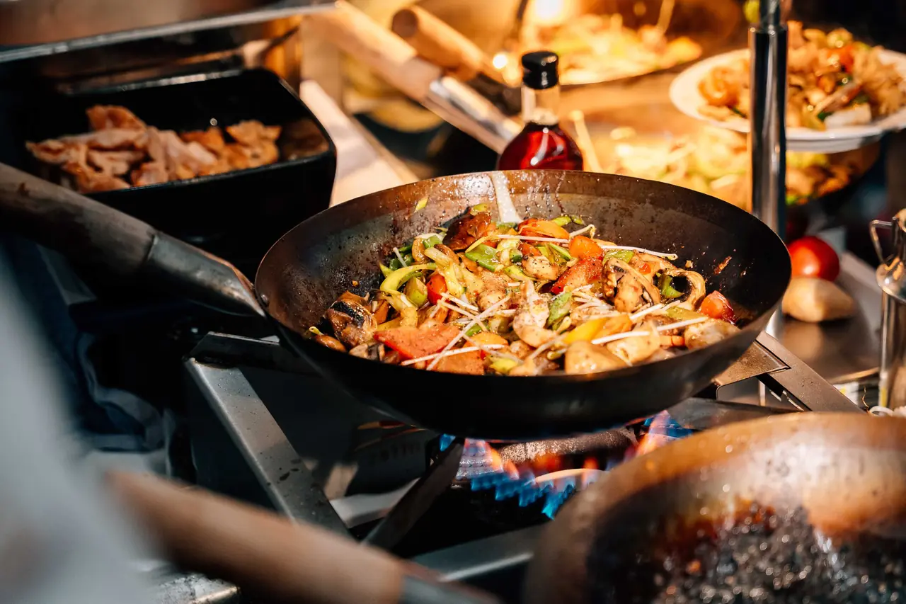 Mehrere Pfannen mit frischen Gerichten auf dem Buffet