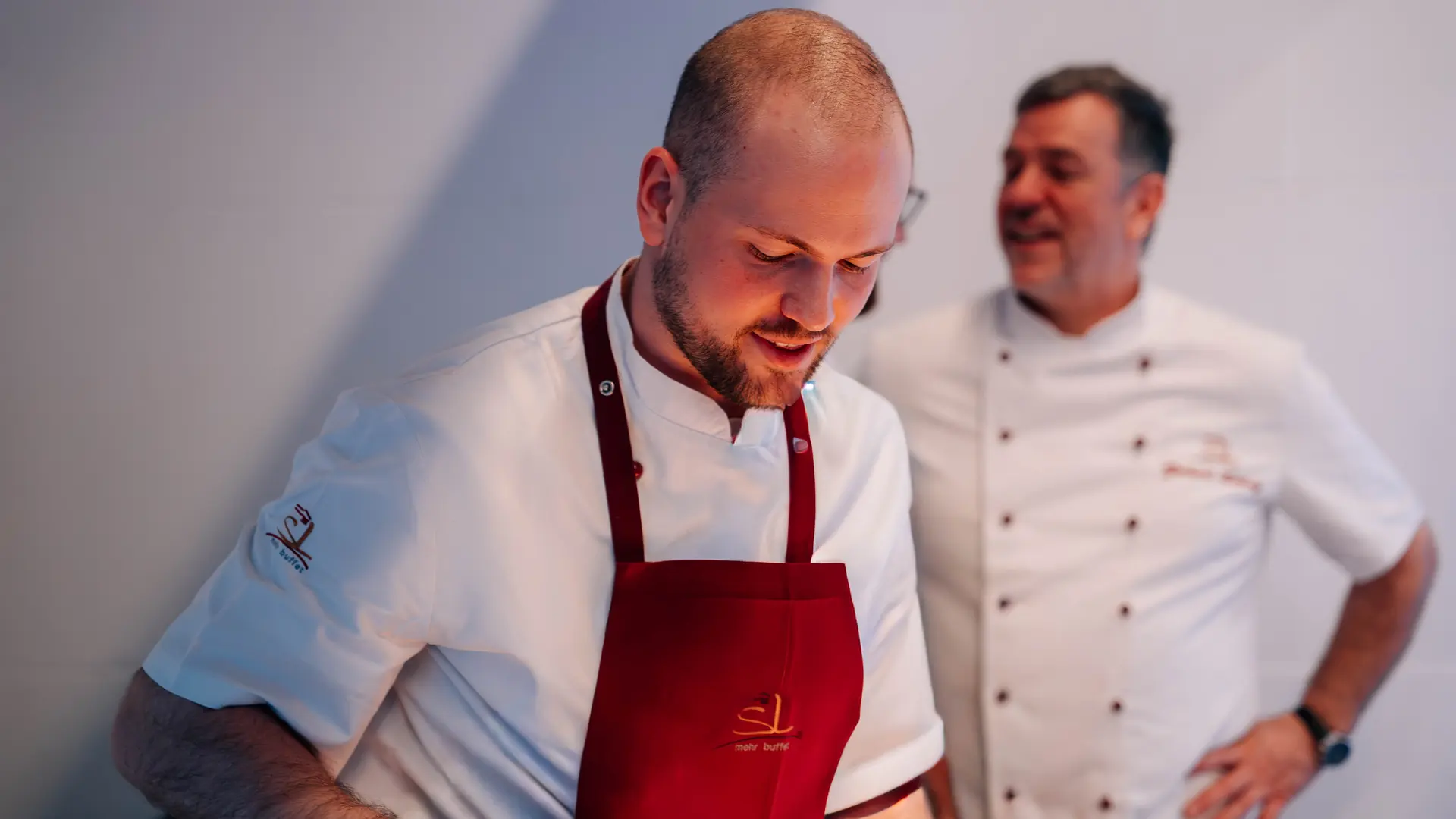 Zwei Köche von SL mehr buffet lachen gemeinsam bei der Arbeit
